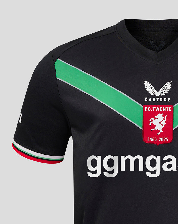 Front close-up of black FC Twente third shirt showing a green diagonal chevron and crest with sponsor text