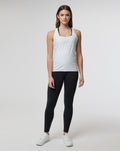 Female model wearing white lightweight Active Technical Vest with square neckline over black leggings and white sneakers.
