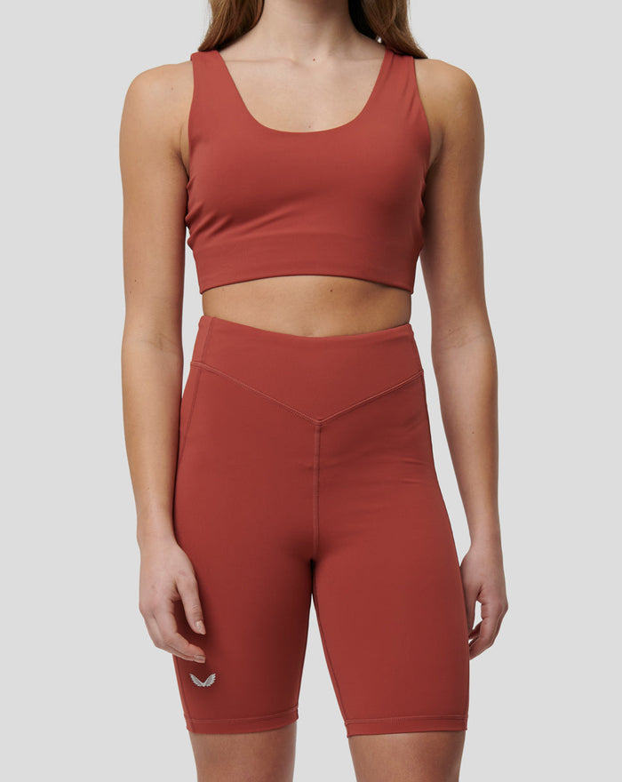 Back view of Rosewood Active Elite Shorts in burnt orange on a model, featuring a deep V waistband and Castore branding on the waistband.