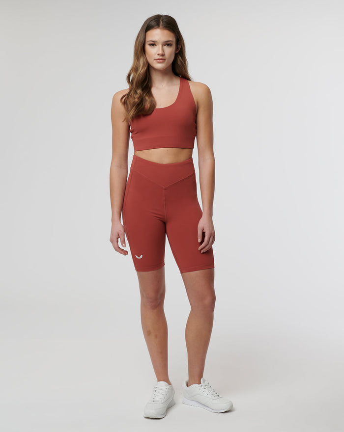 Model wearing rust Rosewood Active Elite Shorts with a matching sports top, front view highlighting the high waist and streamlined athletic fit