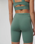 Back view of a model wearing Sage Active Elite Shorts with CASTORE branding on the waistband.
