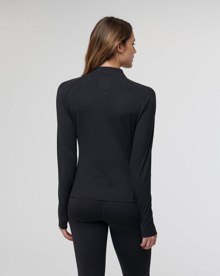 Back view of a model in a black Womens Onyx Active Technical 1/4 Zip showing slim fit long sleeves