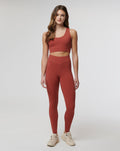 Full body front view of rust Rosewood Active Air Leggings with a matching crop top on a model wearing beige sneakers.