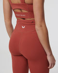 Back view of Rosewood Active Air leggings in rust with a high waistband and Castore logo on the back waistband