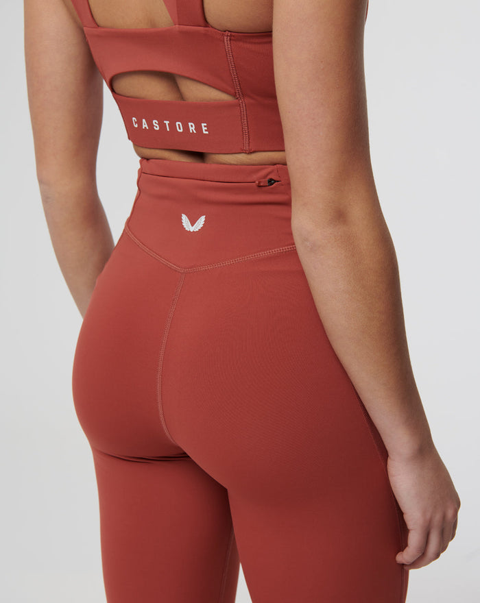 Back view of Rosewood Active Air leggings in rust with a high waistband and Castore logo on the back waistband