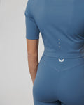 Back view of blue cropped top showing laser cut ventilation and contoured seams