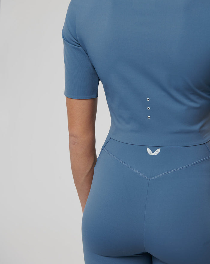 Back view of blue cropped top showing laser cut ventilation and contoured seams