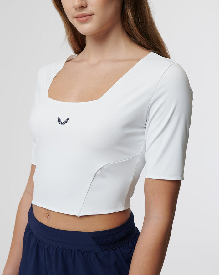 Front view of white active contour crop top with square neckline and small chest logo