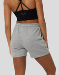 Back view of a model wearing grey Marl Apex shorts with a black crisscross-back sports bra