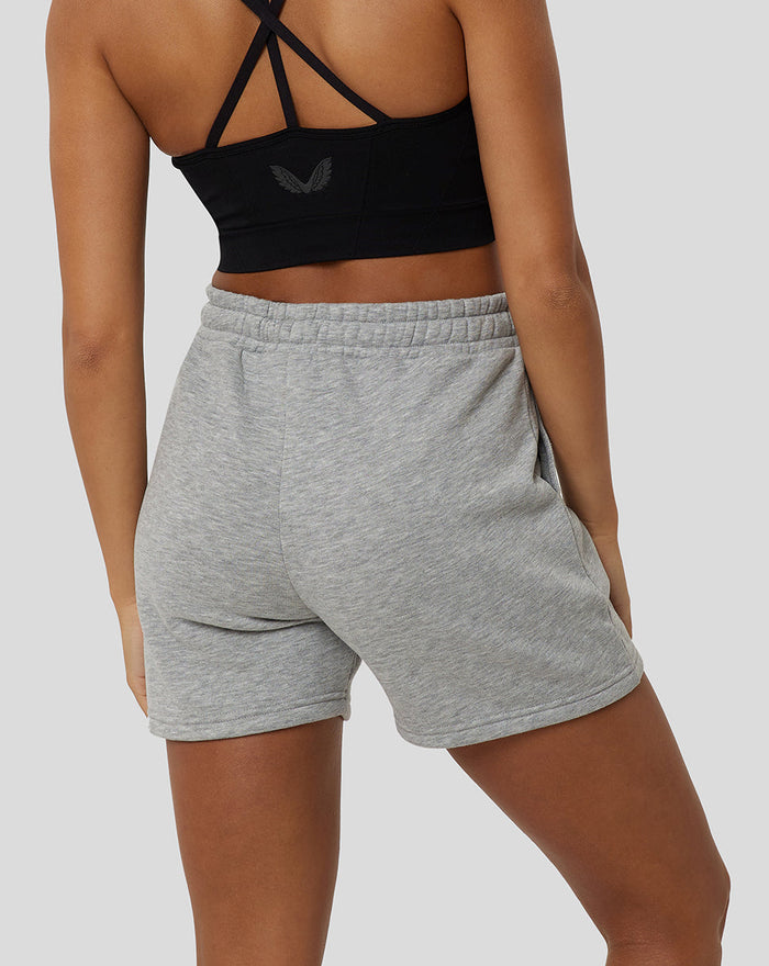 Back view of a model wearing grey Marl Apex shorts with a black crisscross-back sports bra