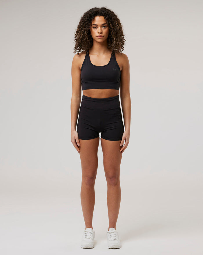 Front view of a model wearing black Onyx BNS training shorts and sports bra for athletic styling.