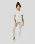 Woman models the Women's Astro Ore Training T-Shirt in pale sage with matching leggings.