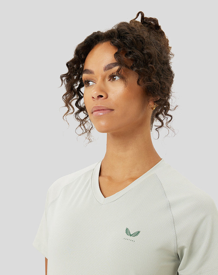 Close-up of a model wearing the pale sage Astro Ore Training T-Shirt with chest logo.