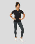 Model wearing black V neck Protek training T shirt with small chest logo, paired with dark heather leggings.