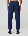 Back view of navy Apex Sweatpants on a model with a single rear pocket and cuffed ankles