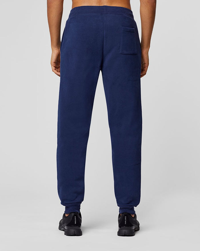 Back view of navy Apex Sweatpants on a model with a single rear pocket and cuffed ankles