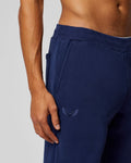 Close-up of navy Apex Sweatpants showing the embroidered Castore wings on the hip area