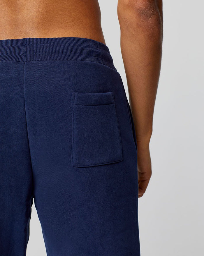 Close up of navy Apex Sweatpants back pocket with ribbed waistband and tonal Castore Wings embroidery