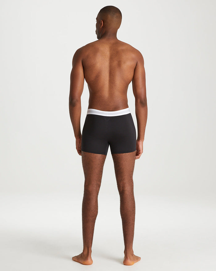 Back view of a man wearing black Onyx boxer shorts with a white elastic waistband.