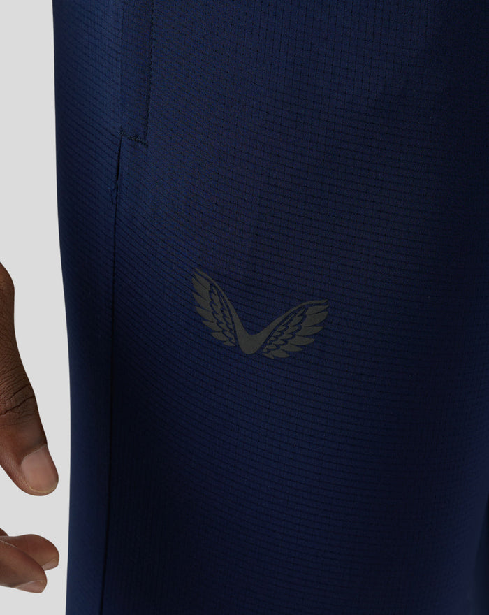 Close-up of navy Pace Trousers fabric with a wing logo
