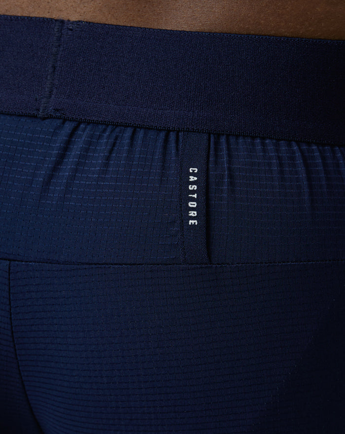 Close-up of navy Pace Trousers waistband with textured fabric and Castore label.