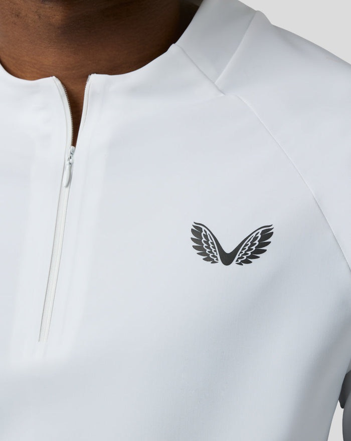 Close-up of the left chest logo on a white BNS 1/4 Zip Top with zipper detail.
