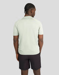 Back view of a man in pale khaki short sleeve training T-shirt.