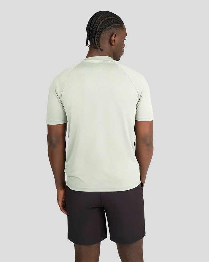 Back view of a man in pale khaki short sleeve training T-shirt.