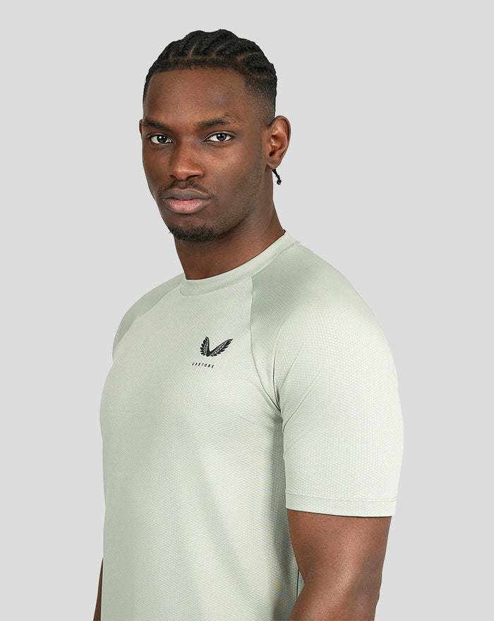 Side profile of a man wearing pale khaki short sleeve training T-shirt.