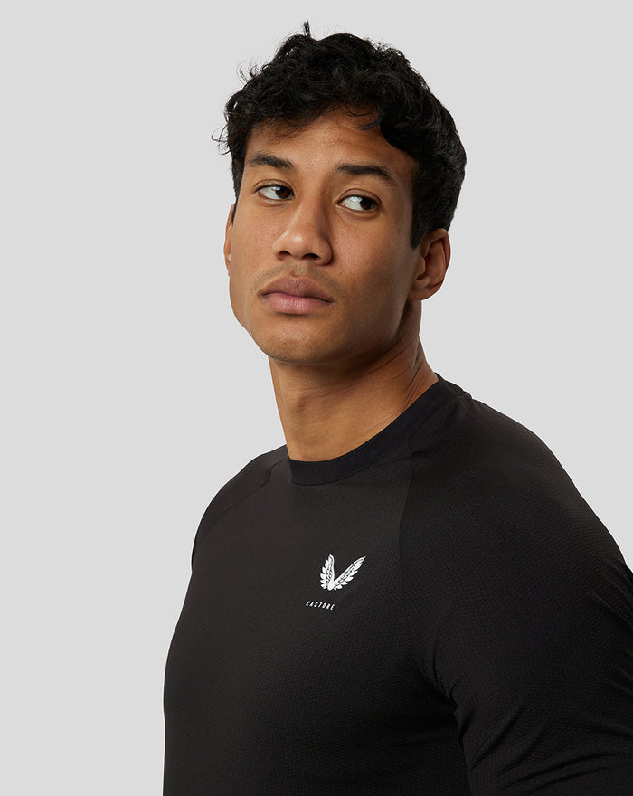 Close-up of a male model in a black Ore Short Sleeve Training T Shirt with a small white logo on the chest.