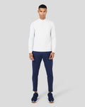 Model wearing white Mist Metatek 1/4 Zip top with a stand collar, paired with navy pants