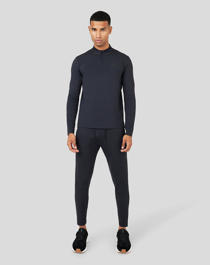Full-body shot of a male model wearing Onyx Metatek 1/4 Zip with zipped side pockets and tonal branding