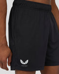 Close up of black 6 inch knitted shorts showing an elastic waistband and Castore logo at the hem.