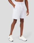 Model wearing white Classics Embroidered Logo Shorts with side pockets and a subtle logo on the leg.