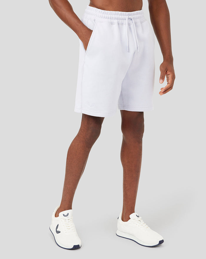 Model wearing white Classics Embroidered Logo Shorts with side pockets and a subtle logo on the leg.