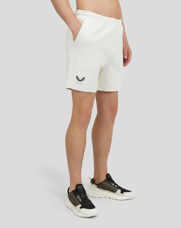 Cream Scuba Shorts with side pockets and Castore graphic on the leg, worn with sneakers.