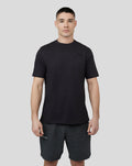 Man wearing a black T-shirt with embroidered Castore logo on chest.