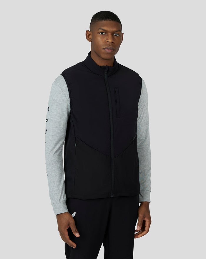 Front view of a male model wearing the Black Cobalt Capsule Hybrid Gilet with a stand collar over a gray long sleeve