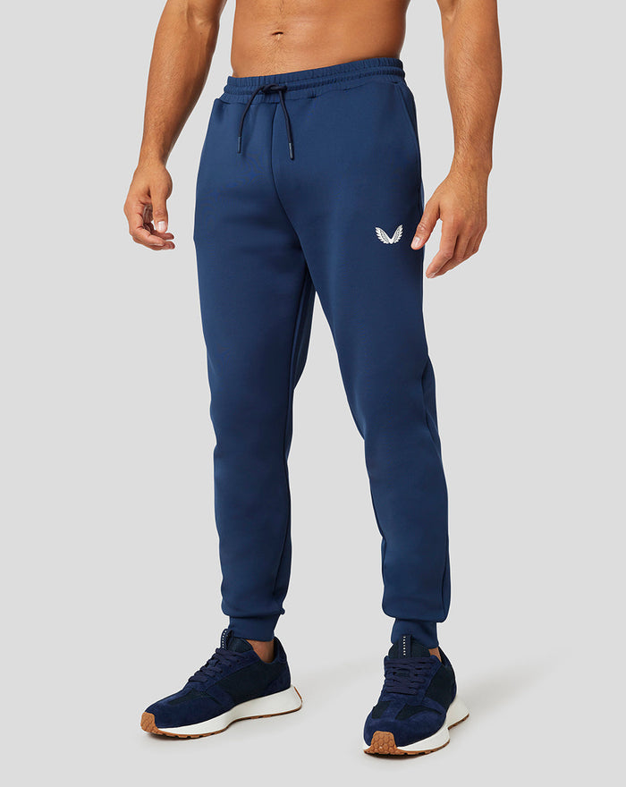 Front view of a man in navy Peacoat Scuba Jogger with a drawstring waist and white Castore logo on the thigh