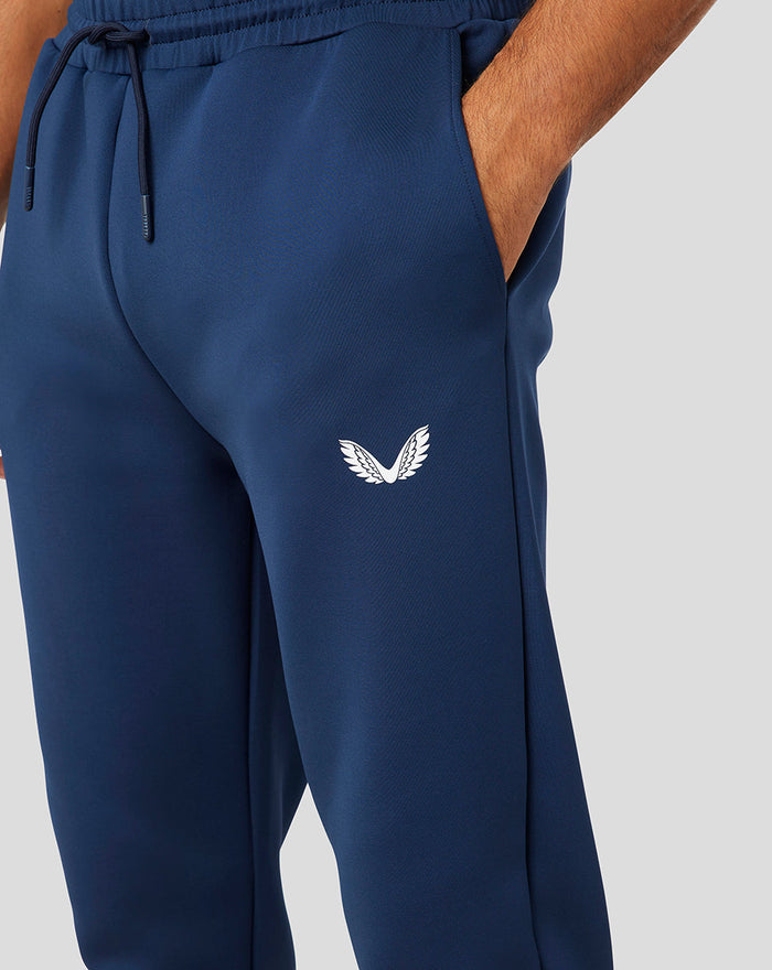 Closeup of navy Peacoat Scuba Jogger leg with a white CASTORE logo on the thigh and a drawstring at the waist.