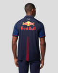 Back view of a man in a navy Red Bull Racing polo with a large Red Bull logo and Red Bull lettering across the back.
