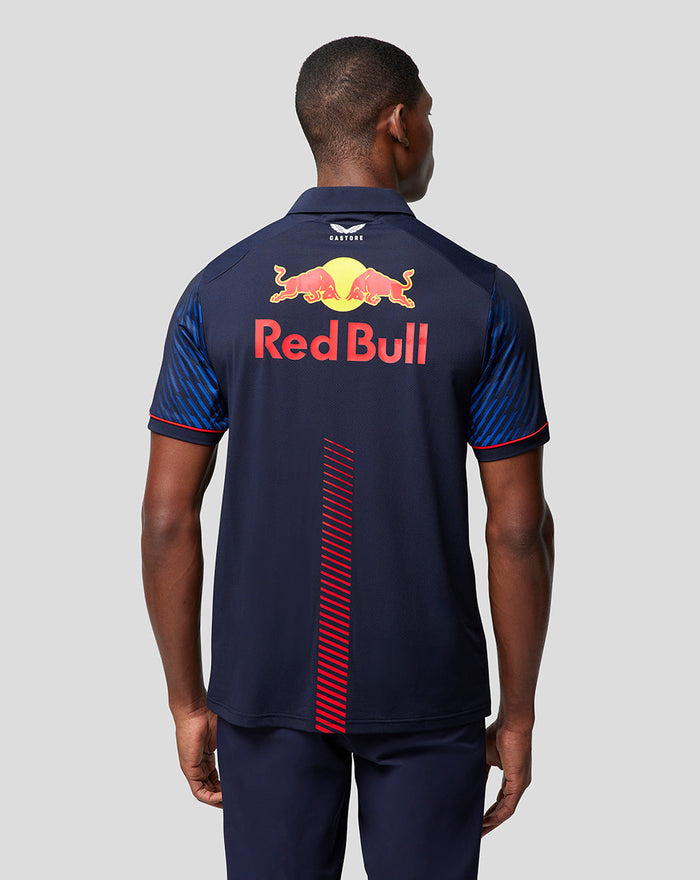 Back view of a man in a navy Red Bull Racing polo with a large Red Bull logo and Red Bull lettering across the back.