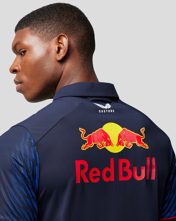Back angled view of a navy Red Bull polo showing large Red Bull crest on the back and Castore branding at the collar.