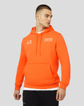 Male model in bright orange overhead hoodie with Verstappen graphic and Oracle Red Bull Racing logo on the chest