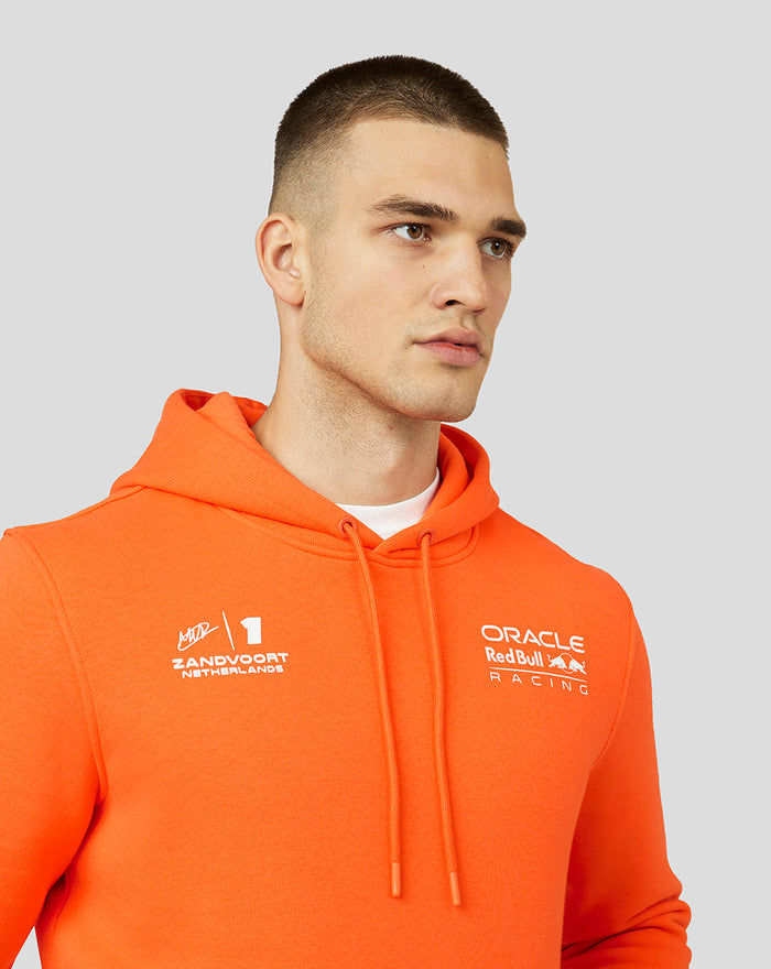 Male model wearing bright orange Oracle Red Bull Racing hoodie with wrap-over hood and front branding.