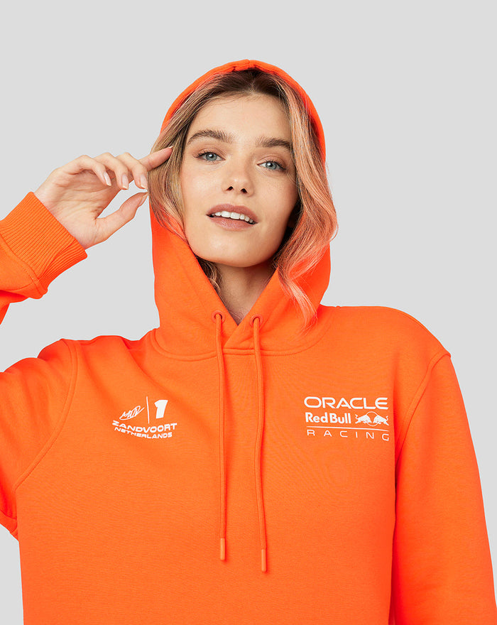 Model wearing bright orange Oracle Red Bull Racing unisex hoodie with Verstappen graphics on the front and back