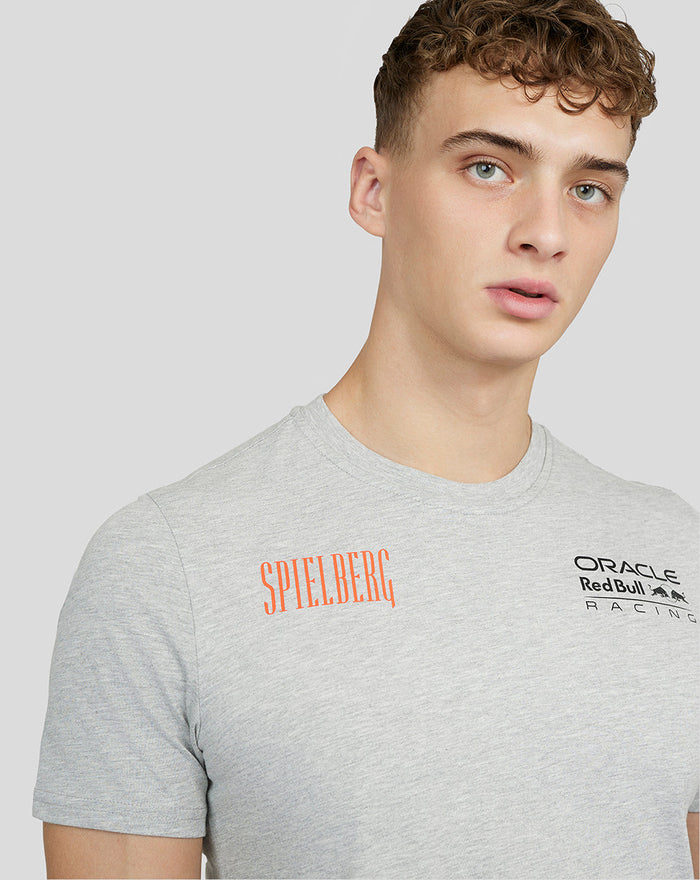 Model wearing grey marl Spielberg short sleeve T shirt with orange Spielberg text on left chest and Oracle Red Bull Racing logo on right chest.